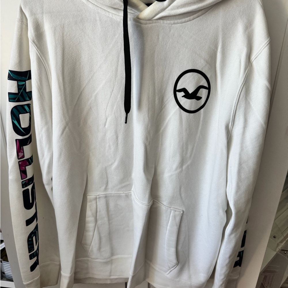 Hollister White Pullover Hoodie with Black Logo and Multicolor Sleeve Text